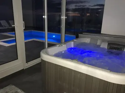 a jacuzzi tub in a room with a window at Villa Por do Sol in Estreito da Calheta