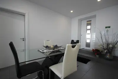 a kitchen with a glass table and black chairs at Villa Por do Sol in Estreito da Calheta