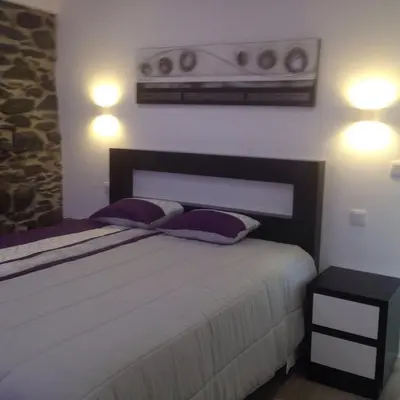a bedroom with a purple bed and a mirror at Villa Por do Sol in Estreito da Calheta