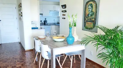 a dining room table with a blue vase on it at CHIQUITA PLACE, Praia da Luz in Luz