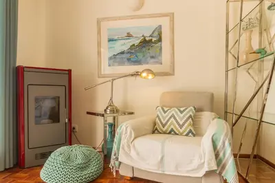 a living room with a chair and a lamp at CHIQUITA PLACE, Praia da Luz in Luz