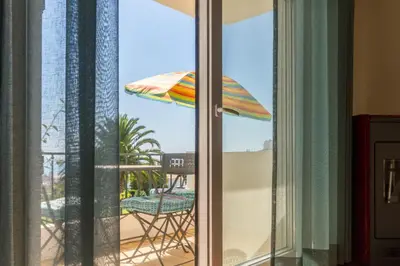 a balcony with an umbrella and a table and a chair at CHIQUITA PLACE, Praia da Luz in Luz