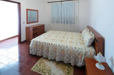 a bedroom with a bed and a dresser and a mirror at Lobos Rustic House II in Câmara de Lobos