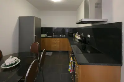 a kitchen with a black counter top and wooden cabinets at Lobos Rustic House II in Câmara de Lobos