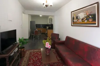 a living room with a red couch and a television at Lobos Rustic House II in Câmara de Lobos