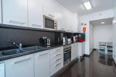 a kitchen with white cabinets and a sink at Central Sea View by Amazing Madeira in Funchal