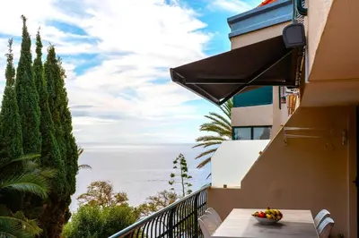 a bowl of fruit on a balcony with a view of the ocean at Central Sea View by Amazing Madeira in Funchal