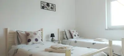 two twin beds in a room with white walls at Beach&Surf Flat in Aljezur