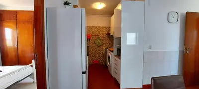 a kitchen with a white refrigerator in a room at Beach&Surf Flat in Aljezur