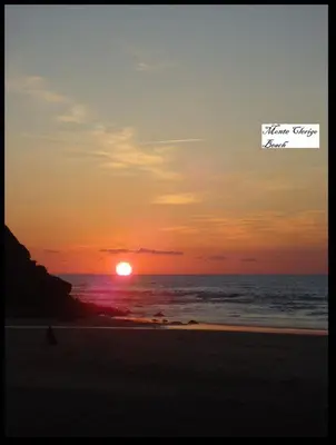 a person walking on the beach at sunset at Beach&Surf Flat in Aljezur