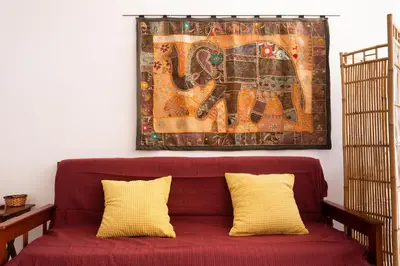 a painting of an elephant hanging above a red couch at Casa Lusco Fusco in Carrapateira
