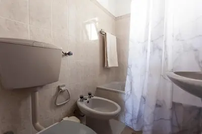 a white bathroom with a toilet and a sink at Casa Lusco Fusco in Carrapateira