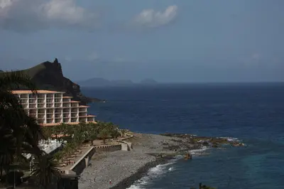 a hotel on a cliff next to the ocean at Canico Bay Apartments in Caniço