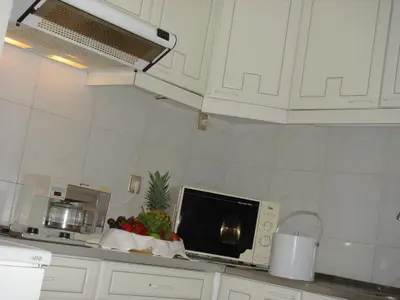 a kitchen with a microwave and some fruit on a counter at Canico Bay Apartments in Caniço