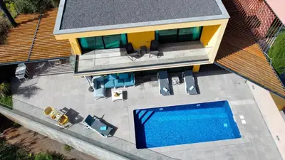 an aerial view of a house with a swimming pool at Eden Sun - A Modern Luxury Villa with a Panoramic View in Prazeres