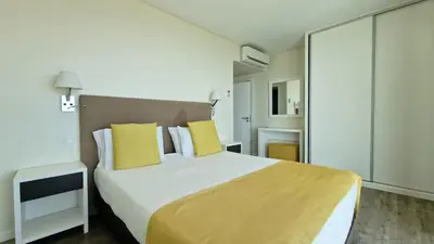 a bedroom with a large bed with yellow pillows at Eden Sun - A Modern Luxury Villa with a Panoramic View in Prazeres