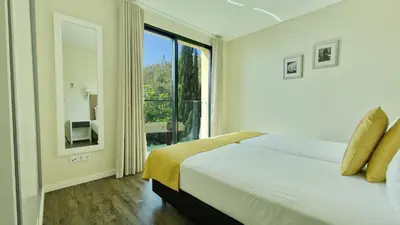 a bedroom with a bed and a large window at Eden Sun - A Modern Luxury Villa with a Panoramic View in Prazeres