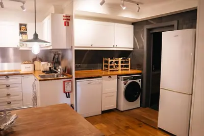 a kitchen with white cabinets and a washer and dryer at Villa Wisteria in Funchal