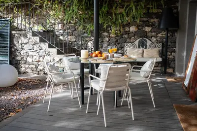 a dining table and chairs on a patio at Villa Wisteria in Funchal