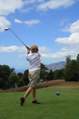 a woman is swinging a kite in a field at A Slice of Paradise - Palheiro Golf in Funchal