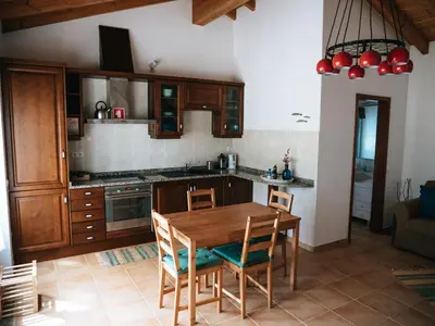 a kitchen with a wooden table and chairs at Soul Farm Algarve - Glamping & Farm Houses in Aljezur