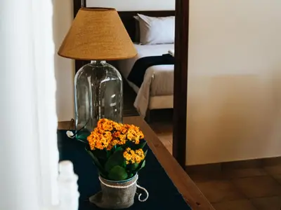 a table with a lamp and a vase with flowers on it at Soul Farm Algarve - Glamping & Farm Houses in Aljezur