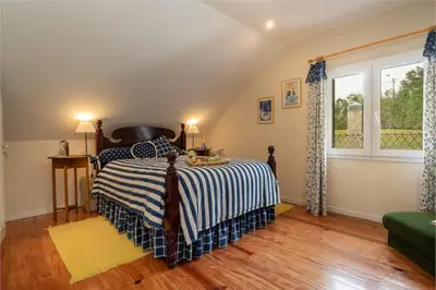 a bedroom with a bed with a striped blanket at Luxury VILLA CAMÉLIA. Mountains, golf, horses, levada walks. in Santo da Serra