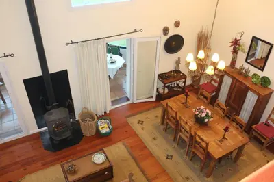 a living room with a table and a fireplace at Luxury VILLA CAMÉLIA. Mountains, golf, horses, levada walks. in Santo da Serra
