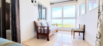 a living room with a chair and a window at Sunset View Flat in Aljezur