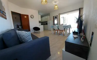 a living room with a blue couch and a table at Sunset View Flat in Aljezur