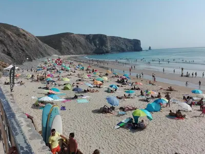a crowd of people on a beach with umbrellas at Sunset View Flat in Aljezur