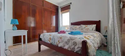 a bedroom with a bed with a wooden headboard at Sunset View Flat in Aljezur
