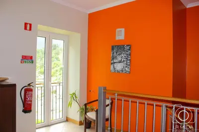 an orange wall in a room with a staircase at Solar do Carvalho in São Vicente