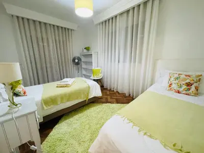 a bedroom with two beds and a green rug at Susy’s Garden in Funchal