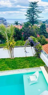 a white chair sitting on top of a swimming pool at Susy’s Garden in Funchal