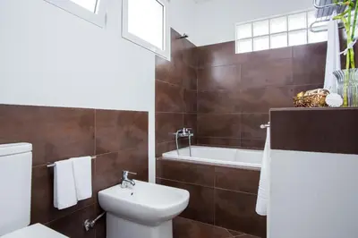 a bathroom with a toilet and a tub and a sink at Susy’s Garden in Funchal