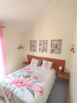 a bedroom with a bed with pink flowers on it at Costa Residence Funchal View in Funchal