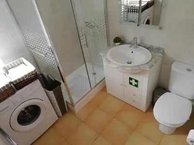a bathroom with a sink and a washing machine at Costa Residence Funchal View in Funchal