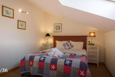 a bedroom with a bed with a quilt on it at TRIPLEX TERRASSE VUE EXCLUSIVE SUR L OCÉAN ,WIFI in Santa Cruz