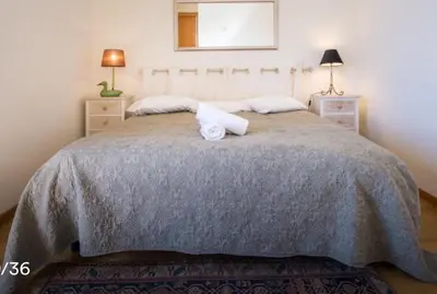 a bedroom with a large bed with two night stands at TRIPLEX TERRASSE VUE EXCLUSIVE SUR L OCÉAN ,WIFI in Santa Cruz
