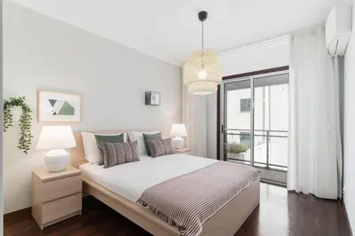 a white bedroom with a bed and a large window at Santa Catarina II by An Island Apart in Funchal