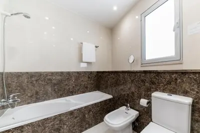 a bathroom with a toilet and a tub and a sink at Santa Catarina II by An Island Apart in Funchal