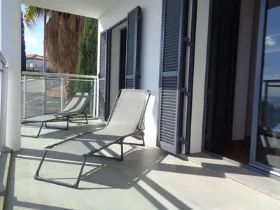 two chairs sitting on the balcony of a house at Paradisus Stylish Family Living in a 3-Bedroom Condo with Pool in Caniço