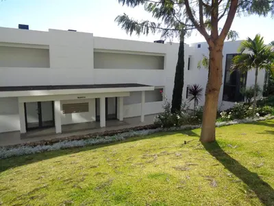 a white building with a tree in a yard at Paradisus Stylish Family Living in a 3-Bedroom Condo with Pool in Caniço