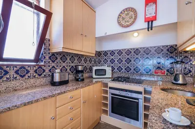 a kitchen with a sink and a stove top oven at H&H seaview in Luz