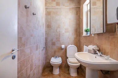 a bathroom with a toilet and a sink at H&H seaview in Luz