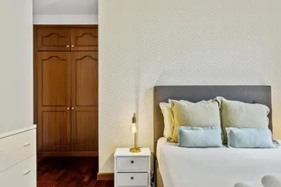 a bedroom with a bed and a night stand with a lamp at Apartamento Netos - By WeHost in Funchal