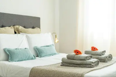 a bedroom with a bed with pillows on it at Apartamento Netos - By WeHost in Funchal