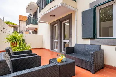 a patio with two chairs and a table at Apartamento Netos - By WeHost in Funchal