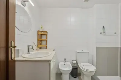 a white bathroom with a toilet and a sink at Apartamento Netos - By WeHost in Funchal